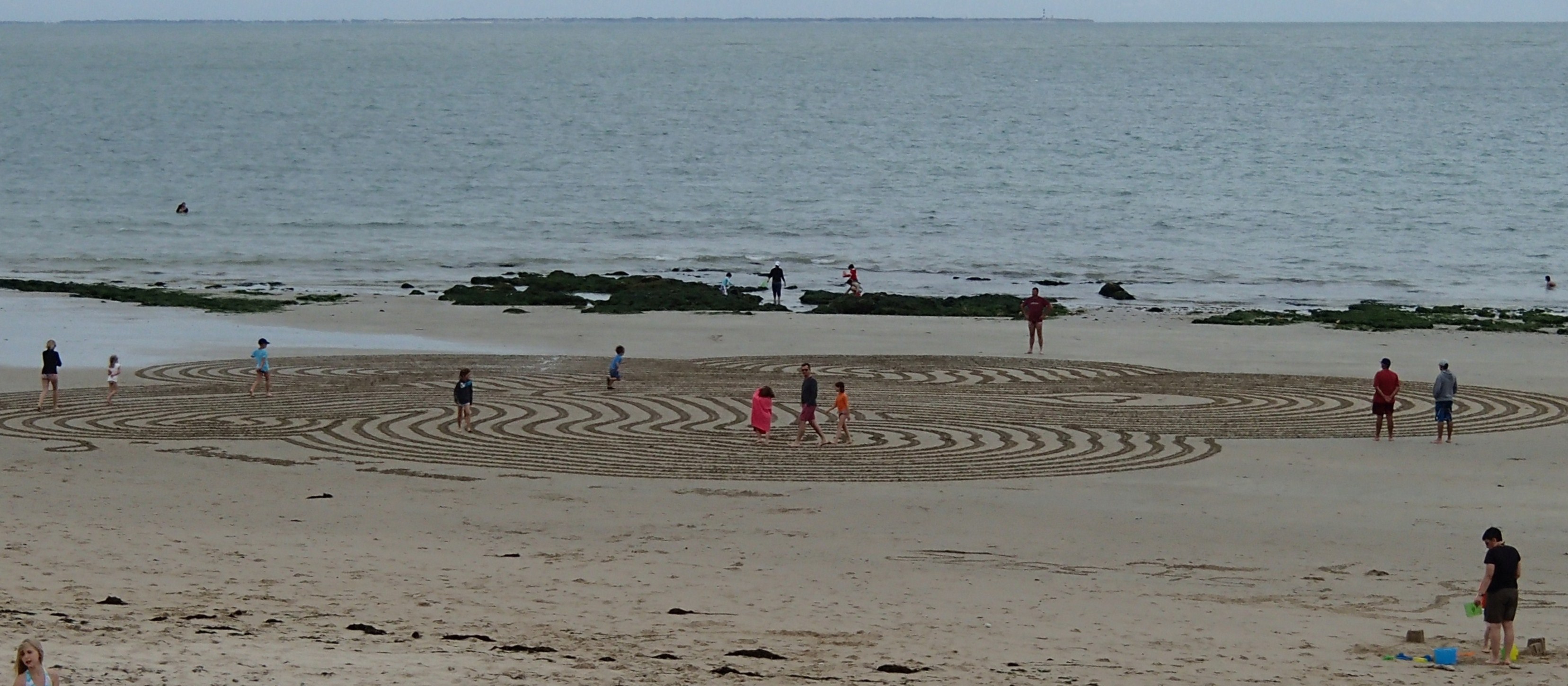 Bord de mer avec un labyrinthe tracé dans le sable